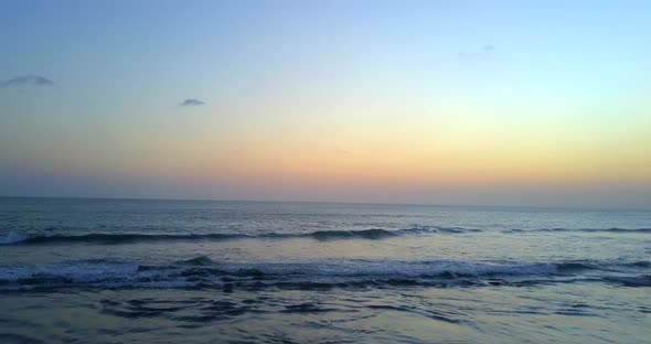 Aerial drone view of the ocean at sunset.