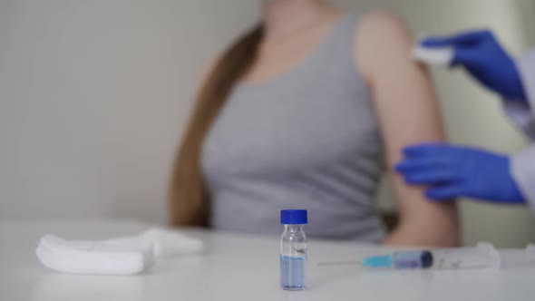 A Doctor in Rubber Blue Gloves Gives a Coronavirus Vaccine to a Patient