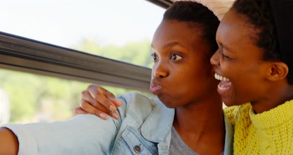 Twin sisters taking selfie with mobile phone in the bus 4k