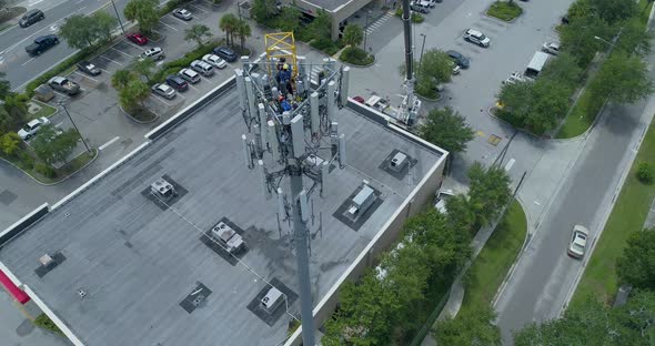 4K Aerial video of technicians climbing cellular communications tower