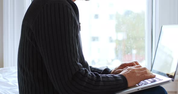 Man using laptop in bedroom 4k