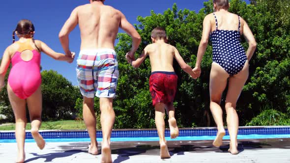 Rear view of family jumping in swimming pool