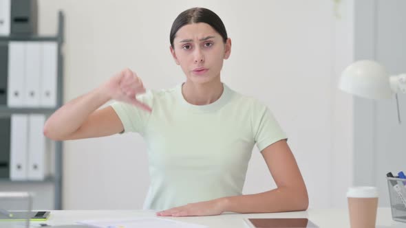 Thumbs Down By Young Latin Woman in Office