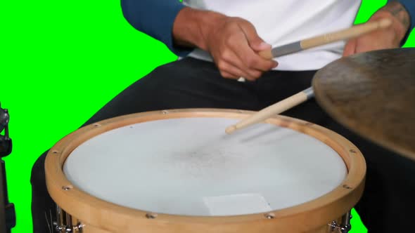 Mid section of drumer playing drum