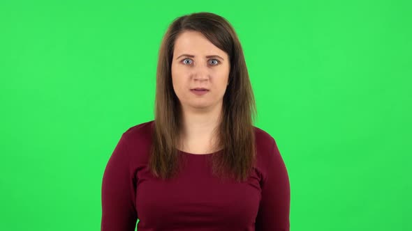 Portrait of Pretty Girl Is Upset, Waving Her Hands in Indignation, Shrugs. Green Screen