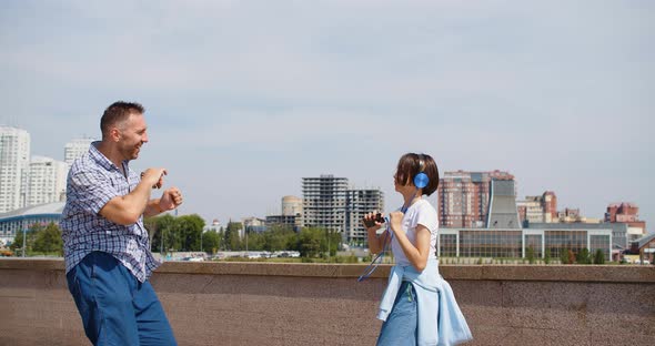 Celebrating the Beginning of the Summer Holidays Father and Daughter are Dancing Against the