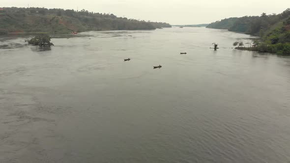 A wide landscape aerial shot of traditional wooden fishing canoes on the river Nile in East Africa.