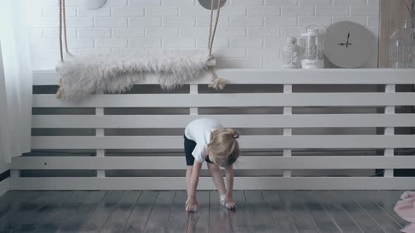 Lovely Blonde Child in White Tshirt Does Quick Exercises