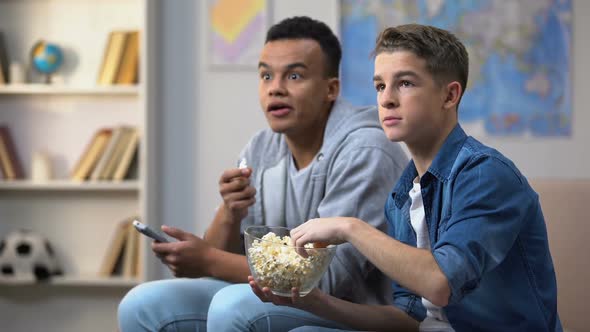 Anxious Multiracial Friends Eating Popcorn and Watching TV Show, Leisure Time