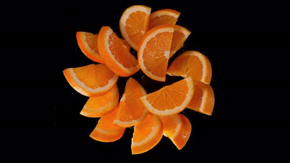 Super Slow Motion Shot of Rotating Exploded Orange Slices on Black at 1000Fps