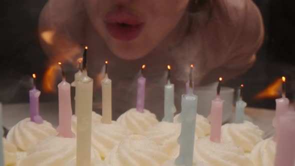 Woman Blowing Out Candles on Birthday Cake