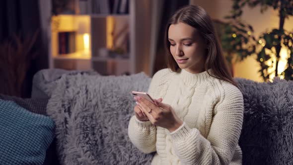 Woman Using Smartphone on Couch