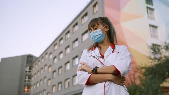 Tired Female Medical Worker in Surgical Face Mask Looks Away