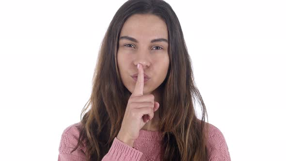 Gesture of Silence by Young Latin Girl, Finger on White Background