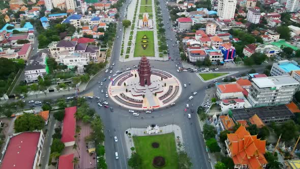 Aerial top down shot of famous Independence Monument and cars driving in roundabout during daylight.