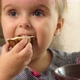 Close up of Preschool girl sitting at a table and eats bread and butter. - VideoHive Item for Sale
