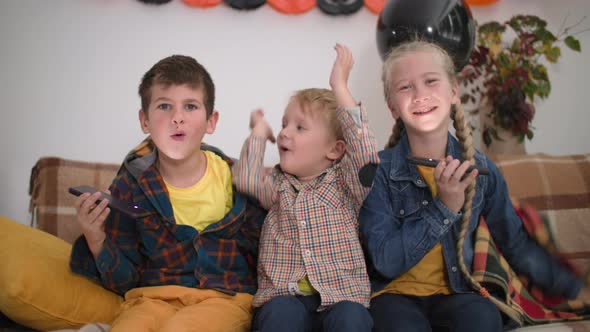 Children Halloween Games Portrait of Adorable Boys and Girls with Long Blond Hair Sitting on Sofa