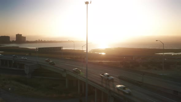 Cars Driving Fast By Freeway and Rams on Sunny Summer Evening at Golden Sunset