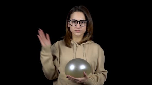 A Young Woman Beats a Balloon with Water. The Ball Is Shaking From Blows. Woman Holds a Ball