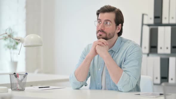 Pensive Young Man Thinking at Work