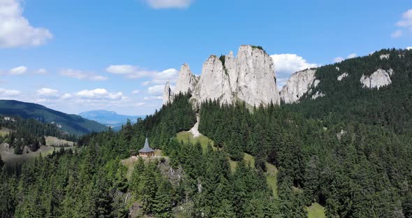 Panorama Of The Lonely Rock Rising Above Evergreen Forest At Piatra Singuratica In Hasmasul Mare, Ro