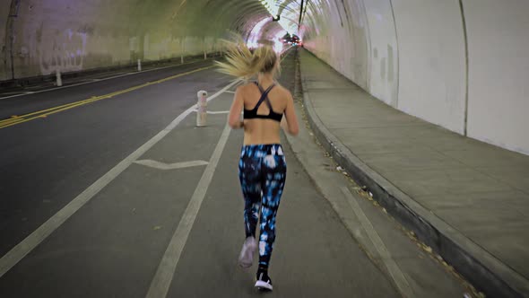 Attractive Woman Jogging Through A Tunnel