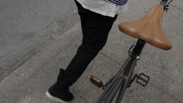 Man with Cycle Walking on Pavement