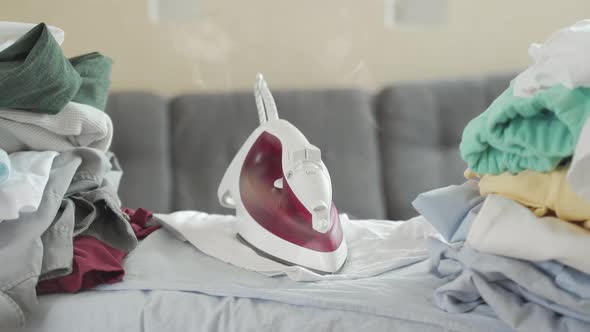 Close Up of the Iron Smoking and Burning on the t Shirt and on the Ironing Board