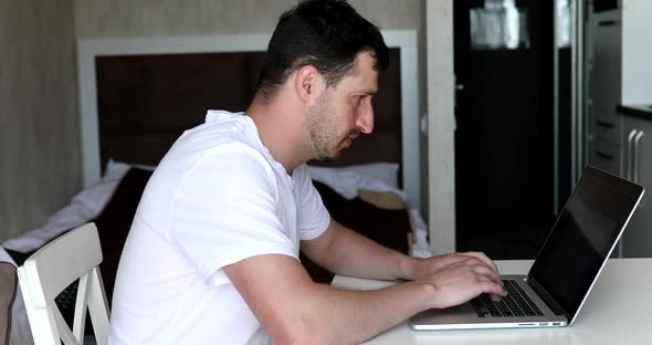 Emotional man celebrating victory or business achievement looking at computer screen.