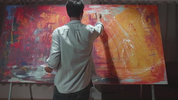 Male Artist Energetically Draws With Paint Brush