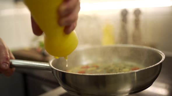 Cook adding lemon sauce into frying pan with ingredients