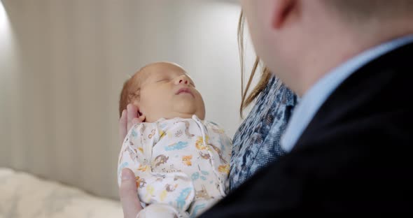 Mother and Father Holding Baby, Loving Child. Close Up on Baby.