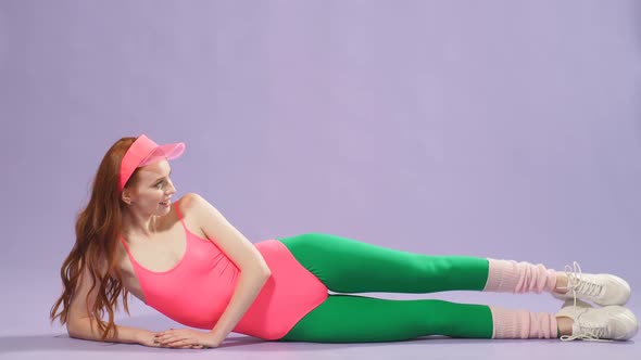 Fit and Active Ginger Girl in Colorful Aerobics Clothes Doing Exercises