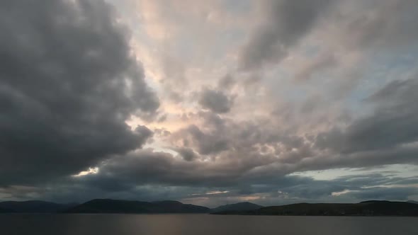 Clouds passing over river and hills - thickening as sunset approaches