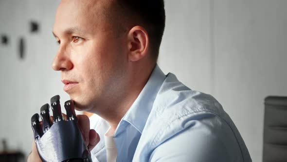 Serious freelance employee man with artificial prothesis thinks holding head on hands