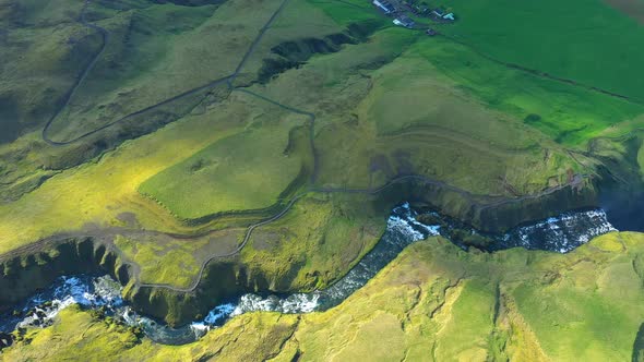 Aerial Flying Above the Vibrant Green Lava Hills and the River Skogar in Iceland