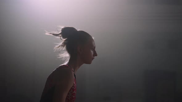 Young Female Gymnast is Doing Somersault on Spring Floor at Competition or Training Slow Motion