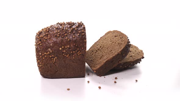 Beautiful Loaf of Black Sliced Bread Ready for Breakfast with Sprinkles Spinn on White Background