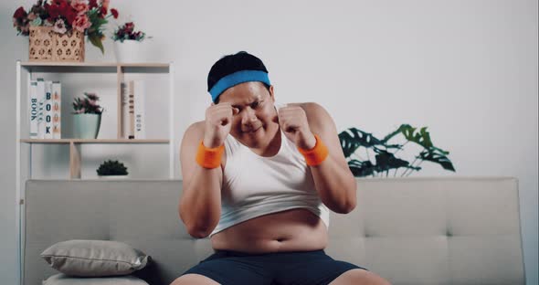 Overweight man in sportswear and wrist wraps boxing