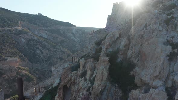 Aerial Close Up View of an Old Mine, Factory Built on the Side of a Mountain in Sunset Light