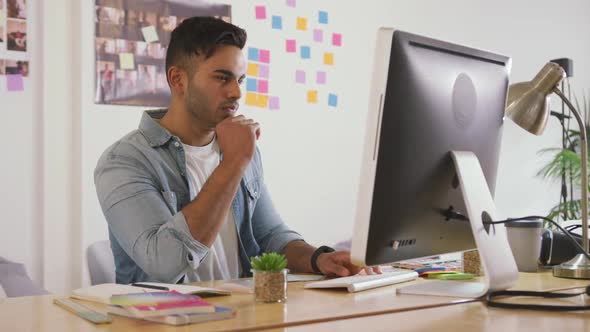 Mixed race man working on computer in creative office