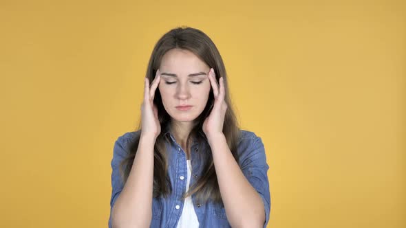 Pretty Woman with Headache Isolated on Yellow Background