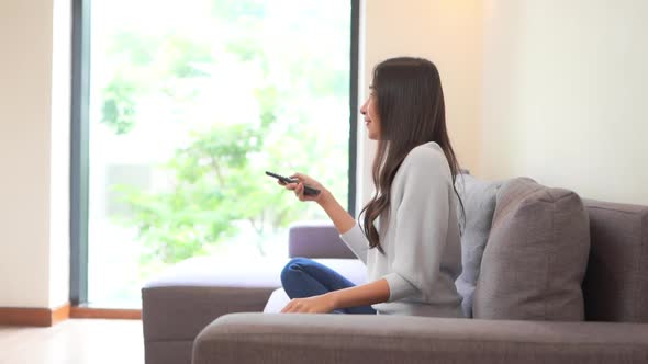 Woman use remote for change television