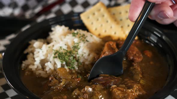 Spoonful of tasty cajun chicken and sausage gumbo, slow motion slider close up 4K