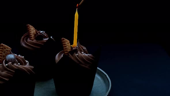 Female Hands Making Delicious Chocolate Cupcakes with Cream on Dark Background