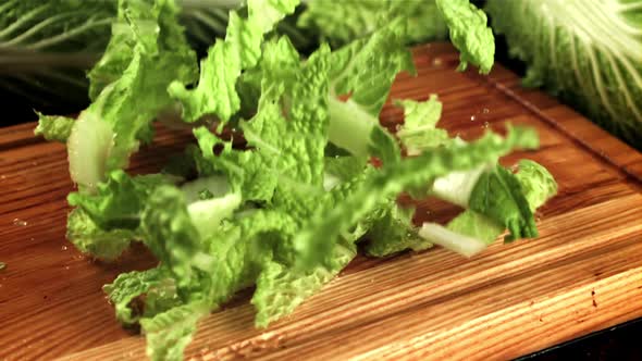 Pieces of Beijing Cabbage Fall on a Wooden Cutting Board