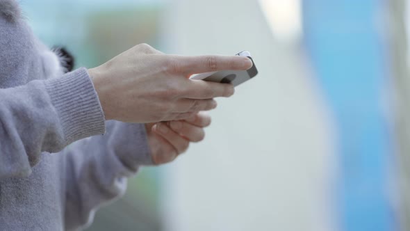 Female Hands Using Smartphone on Blurred Background