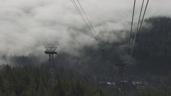 Aerial View of Gondola Tower Over Evergreen Trees Covered During Winter Season Day