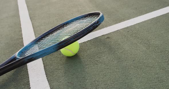 Video of tennis racket and ball lying on tennis court