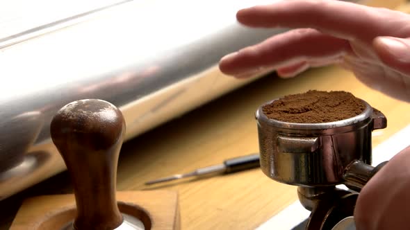 Hand of Man Tamping Coffee.